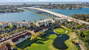 A coastal hotel with a golf course, a bridge, and a marina.
