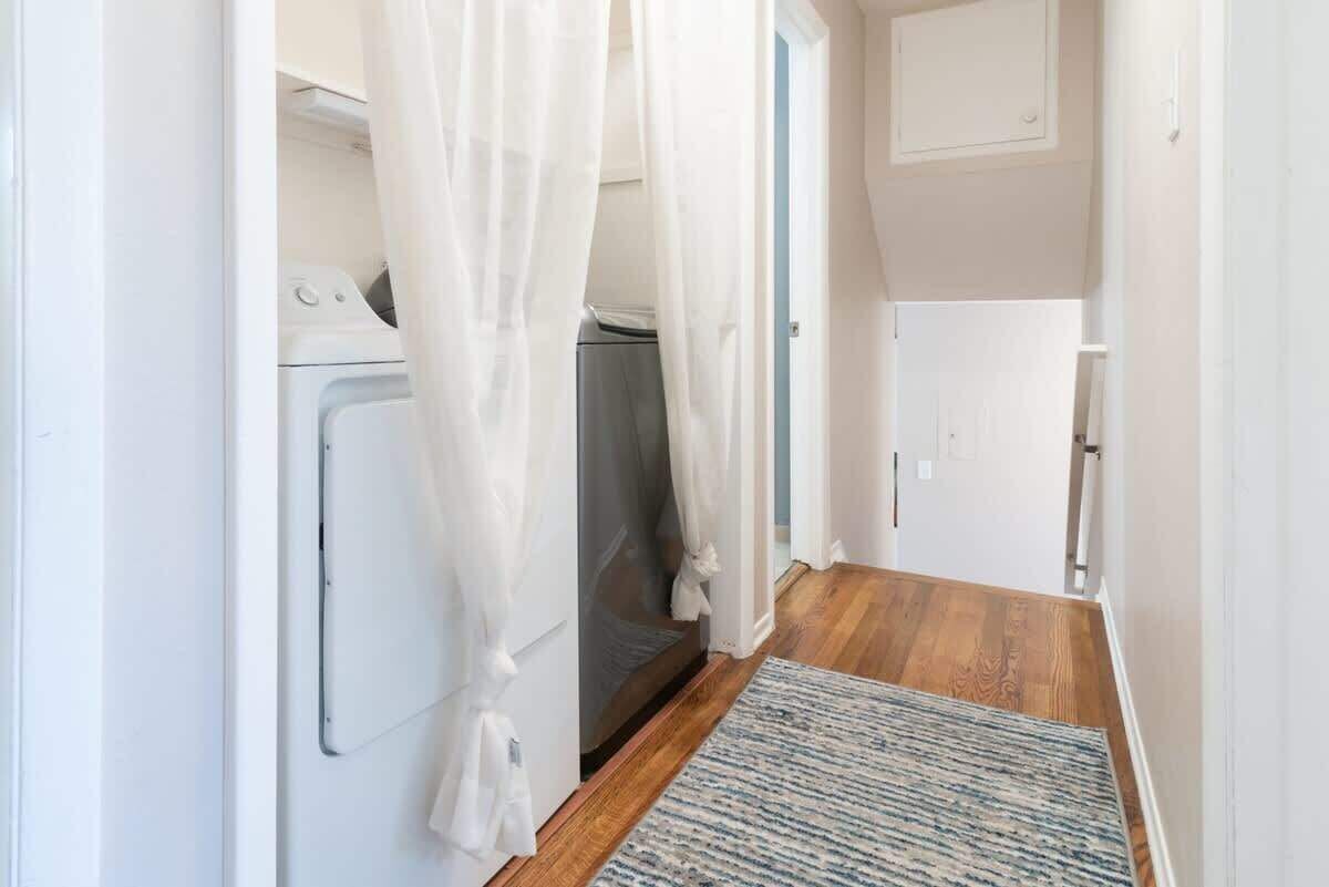 A laundry room with a washing machine, dryer, and a small cabinet.