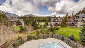 A residential area with a swimming pool, houses, and a mountainous backdrop.