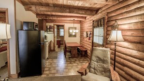 L’intérieur d’une cabane en rondins comprend une cuisine, un coin repas et un espace salon confortable.