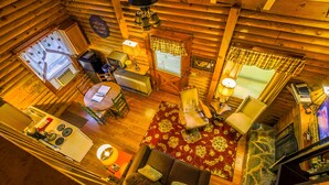A cozy log cabin interior with a dining area, kitchen, and a fireplace. - Queen Bedroom with Loft (Blowing Rock)