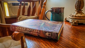 A book titled "Harry Potter and the Chamber of Secrets" on a wooden table.