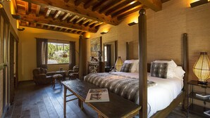 A four-poster bed with a wooden headboard, a bedside table with a book, and a lamp on a nightstand. - Hotel Cigarral de las Mercedes (Toledo)