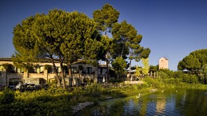 A riverside hotel with outdoor seating and a pond with swans. - Hotel Cigarral de las Mercedes (Toledo)