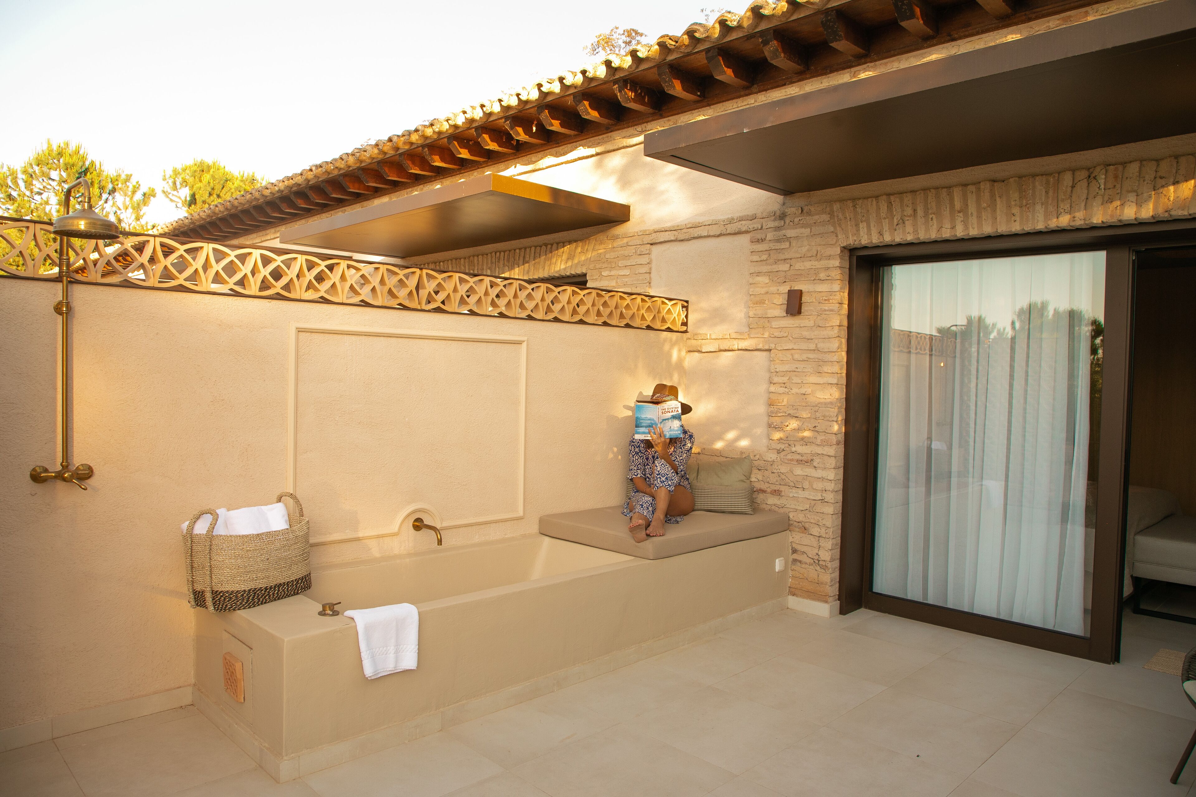 A spa area with a bathtub, a bench, and a reading area with a book.