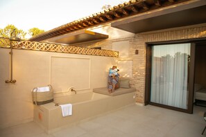 A spa area with a bathtub, a bench, and a reading area with a book. - Hotel Cigarral de las Mercedes (Toledo)