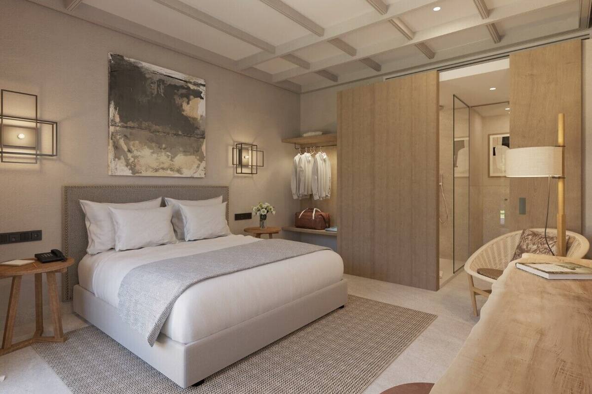 A modern bedroom with a large bed, bedside tables, a mirror, and a wardrobe.
