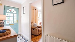 Ein Flur mit einer blauen Tür, einem gerahmten Bild an der Wand und einer Heizung.
