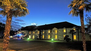 Un hotel con fachada de piedra, varias ventanas y un letrero que indica que es un hotel.