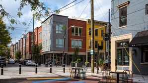 A street view with colorful buildings, a crosswalk, and outdoor seating. - Soaring 2-Bedroom Parkside Loft Walkable to it All (Cincinnati)