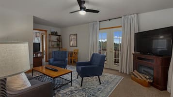 Suite Deluxe | Área de sala de estar | Televisión de pantalla plana de 55 pulgadas con canales vía satélite