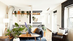 Un salon moderne avec un canapé, une table basse et des plantes décoratives.