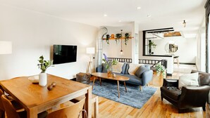 Un salon moderne avec une table à manger en bois, un canapé et un fauteuil en cuir.