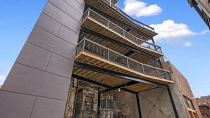 A multi-story building with a modern architectural design, featuring a prominent cantilevered section and a series of balconies. - Findlay Suites - Perfect Location Over the Rhine (Cincinnati)