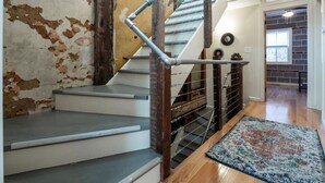 Eine Treppe mit Metallgeländer, einer Holzhandläufe und einem Teppich auf dem Boden.