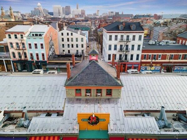 Un bâtiment doté d’un toit végétalisé, une enseigne indiquant « FIND MARKET », et une statue en arrière-plan.