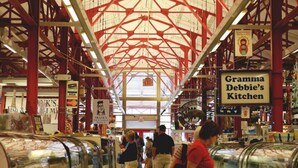 An indoor market with a high ceiling and red beams, featuring signs for 'Frank's Fish & Seafood Market' and 'Grammar Debbie's Kitchen'. - Over the Rhine Luxury MicroSuite On Findlay Market (Cincinnati)