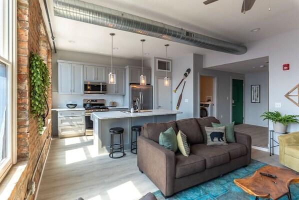 Een modern appartement met een keuken, woonruimte en een eethoek.