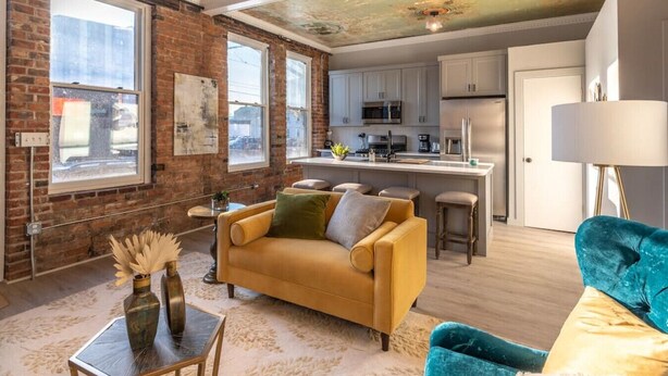 A modern living room with a sofa, a coffee table, and a blue armchair.