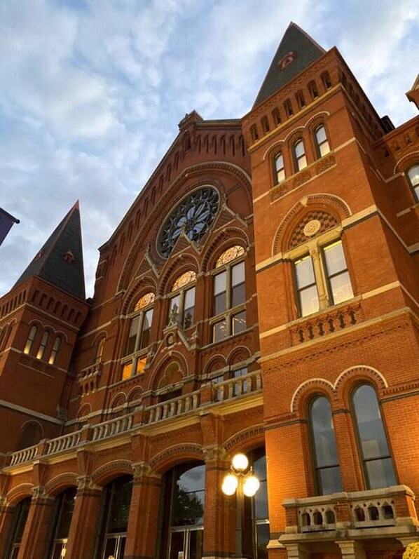 A large brick building with a prominent clock tower and arched windows.