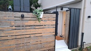 Una valla de madera con una puerta blanca y escalones que conducen a un portón.