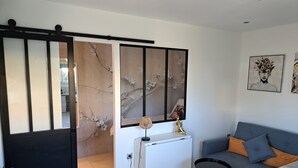 Una sala moderna con un sofá, una mesita y una lámpara decorativa.