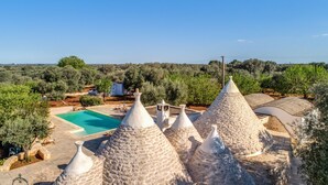 A view of a villa with a swimming pool, stone conical roofs, and surrounding olive trees. - Trullo La Succulenta - Le Case di Valentina (Ceglie Messapica)