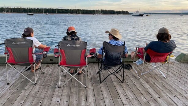 Four people seated on a wooden deck facing a body of water with sailboats. - Getaway St Andrews - Bright Spacious Vacation Home (St. Andrews)