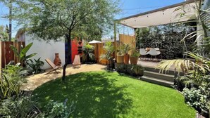 A well-maintained garden with a lawn, potted plants, and a seating area. - Angeleno Oasis: Cute Guest House w/ Private Patio (YUC)