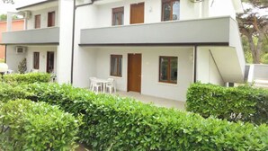 Ein zweistöckiges Gebäude mit flachem Dach, weißen Außenwänden und einem kleinen Balkon im oberen Geschoss.