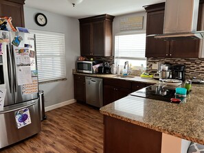 Enjoy cooking in this well-equipped kitchen with a central island, stovetop, and ample workspace.