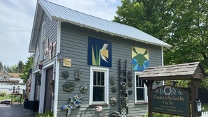 A building with a sign reading "Window to the Garden Fine Art for the home & garden by appointment or chance."