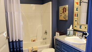 A bathroom with a bathtub, toilet, and sink.