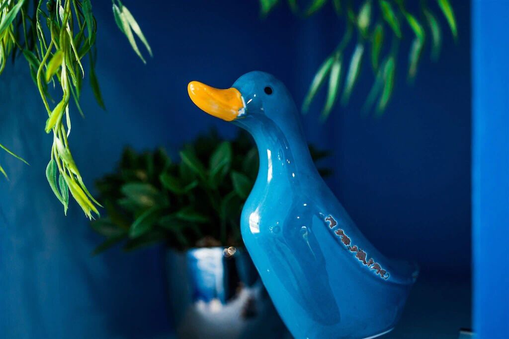 A blue ceramic duck with an orange beak.