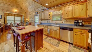 Una cocina amplia con armarios de madera, una isla central y un lavavajillas.