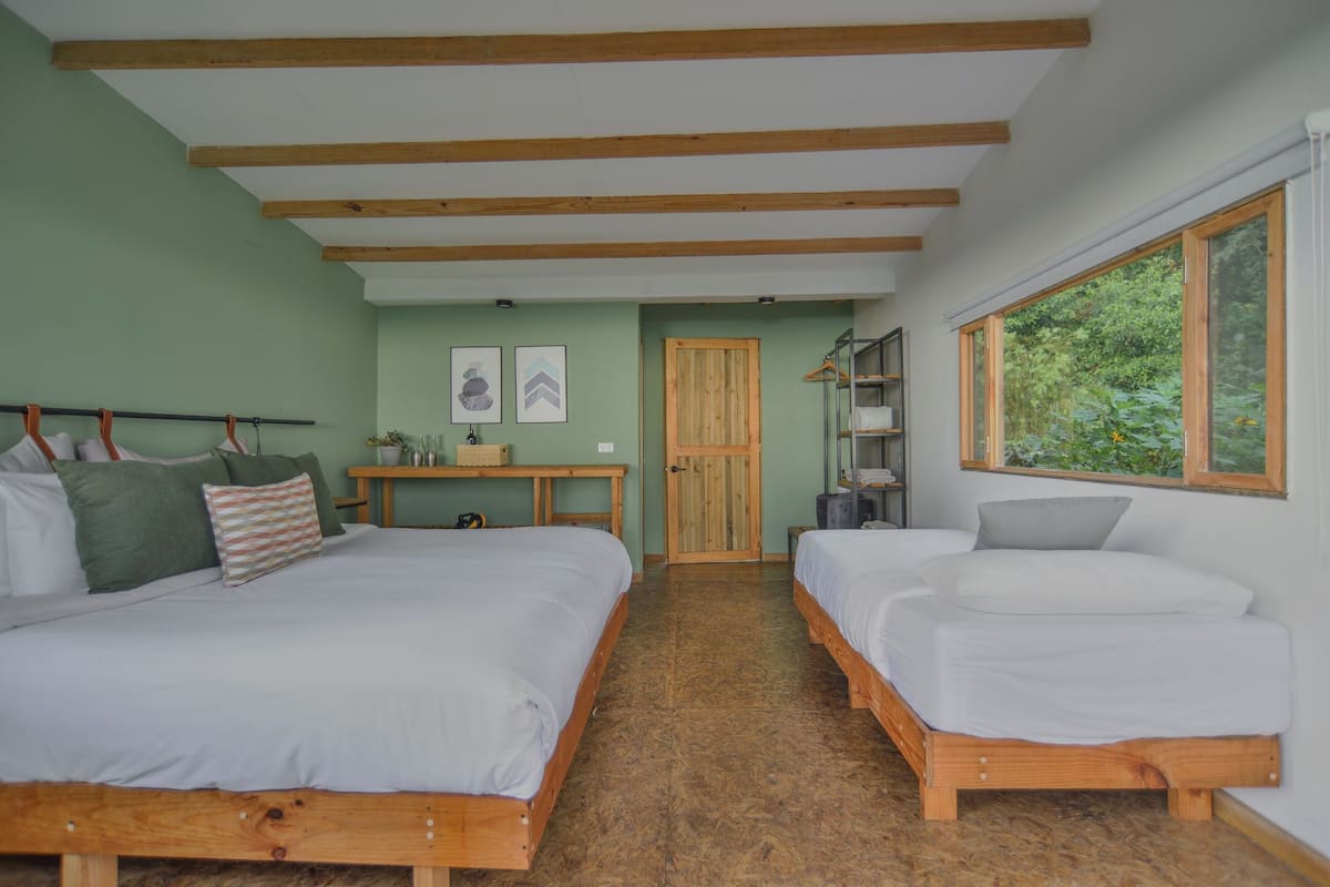 A room with two wooden beds, a desk, and a wardrobe.