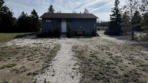 A rustic wooden building with a gravel path leading to the entrance. - Cabin in Little Cove Adventure park, Tobermory  Cabin 14 (Tobermory)