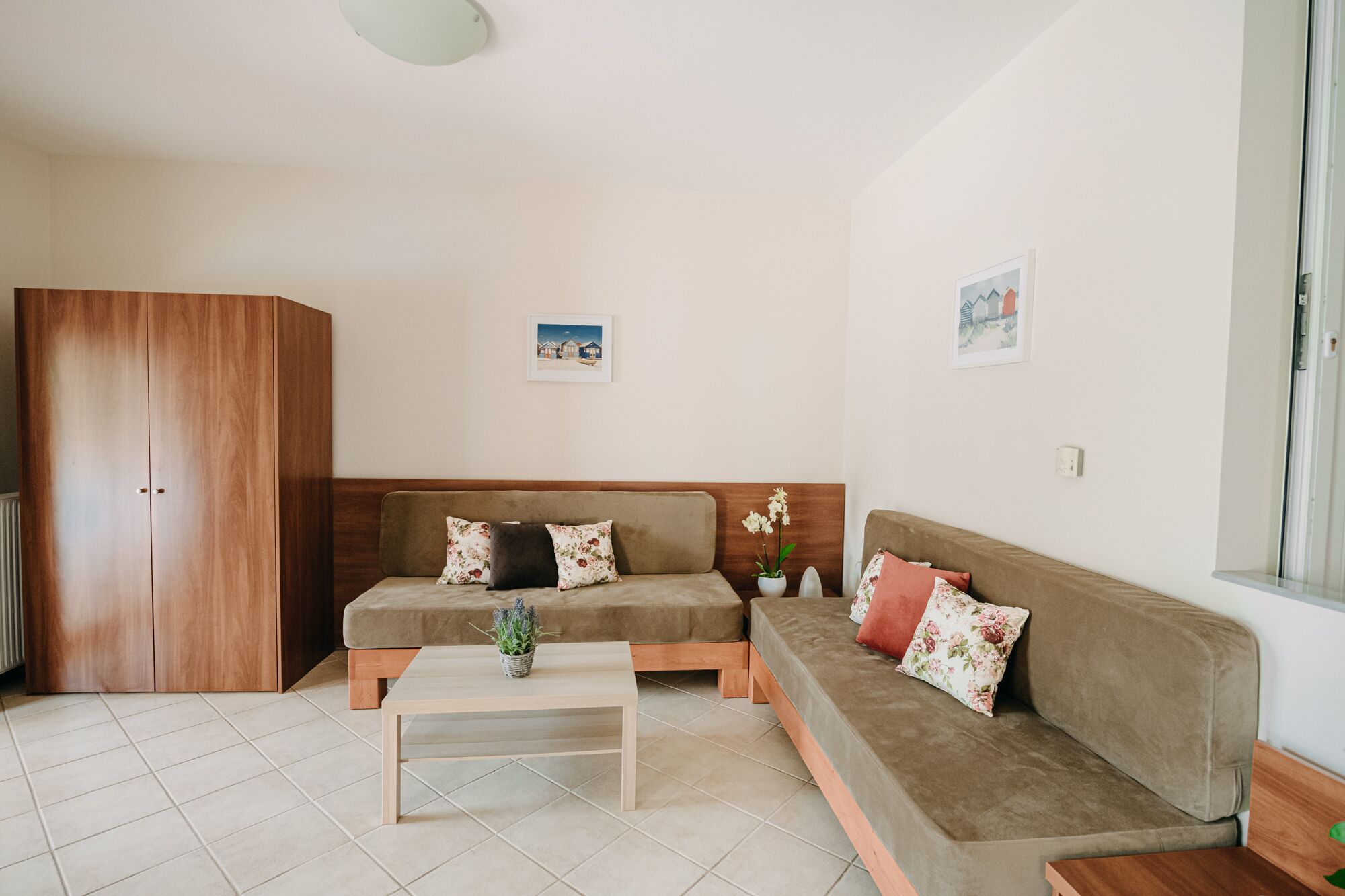 Ein gemütliches Wohnzimmer mit einer Couch, einem Couchtisch und einem Holzschrank.