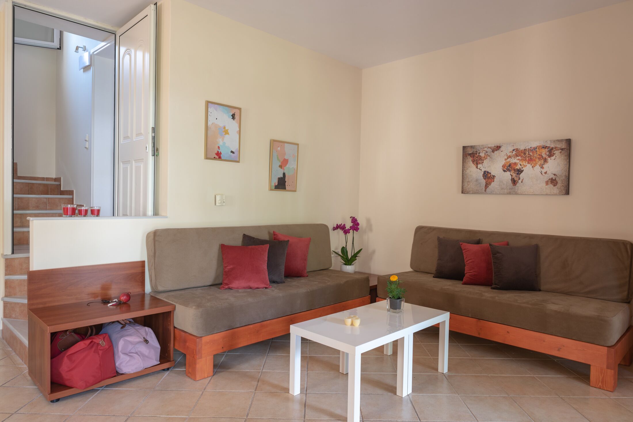 A living room with two sofas, a coffee table, and a staircase leading to an upper floor.