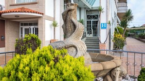 A stone fountain with a statue in front of a hotel entrance. - Ardora Restaurant and Hotel (Sanxenxo)