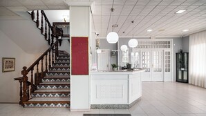 A spacious lobby with a central island, a staircase with patterned steps, and a modern ceiling design. - Ardora Restaurant and Hotel (Sanxenxo)
