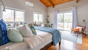 Un dormitorio con cama, escritorio, silla y ventana.