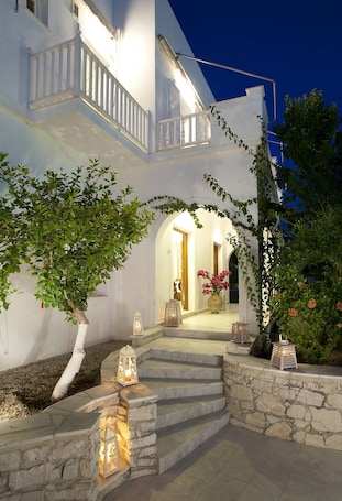 A white building with a stone staircase leading to a balcony.