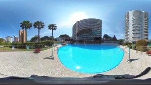 Une piscine à l’eau d’un bleu limpide, entourée d’une terrasse carrelée.
