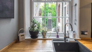 Eine Küche mit Fenster, Spüle und Topfpflanzen.