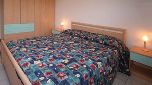 Ein Schlafzimmer mit einem hölzernen Bett, floralem Bettzeug und Nachttischlampen.