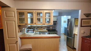 Una cocina con armarios de madera, una isla central y un refrigerador.