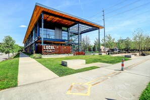 LOCAL restaurant sits on a grassy area with a clear sidewalk leading up to its entrance.
