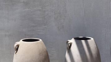 Deux vases en céramique placés contre un mur uni.