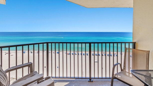 A balcony with a view of a beach and ocean.